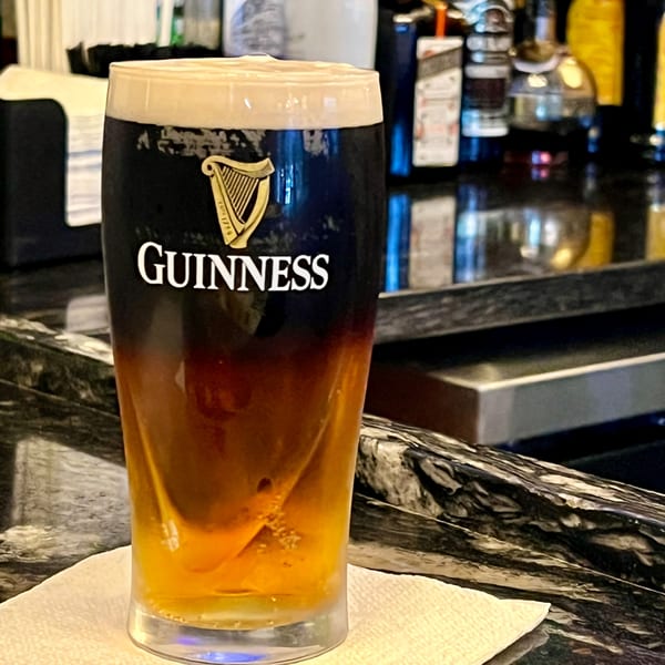 A Guinness beer with a golden bottom layer, on a bar counter at Watermark of Wading River.
